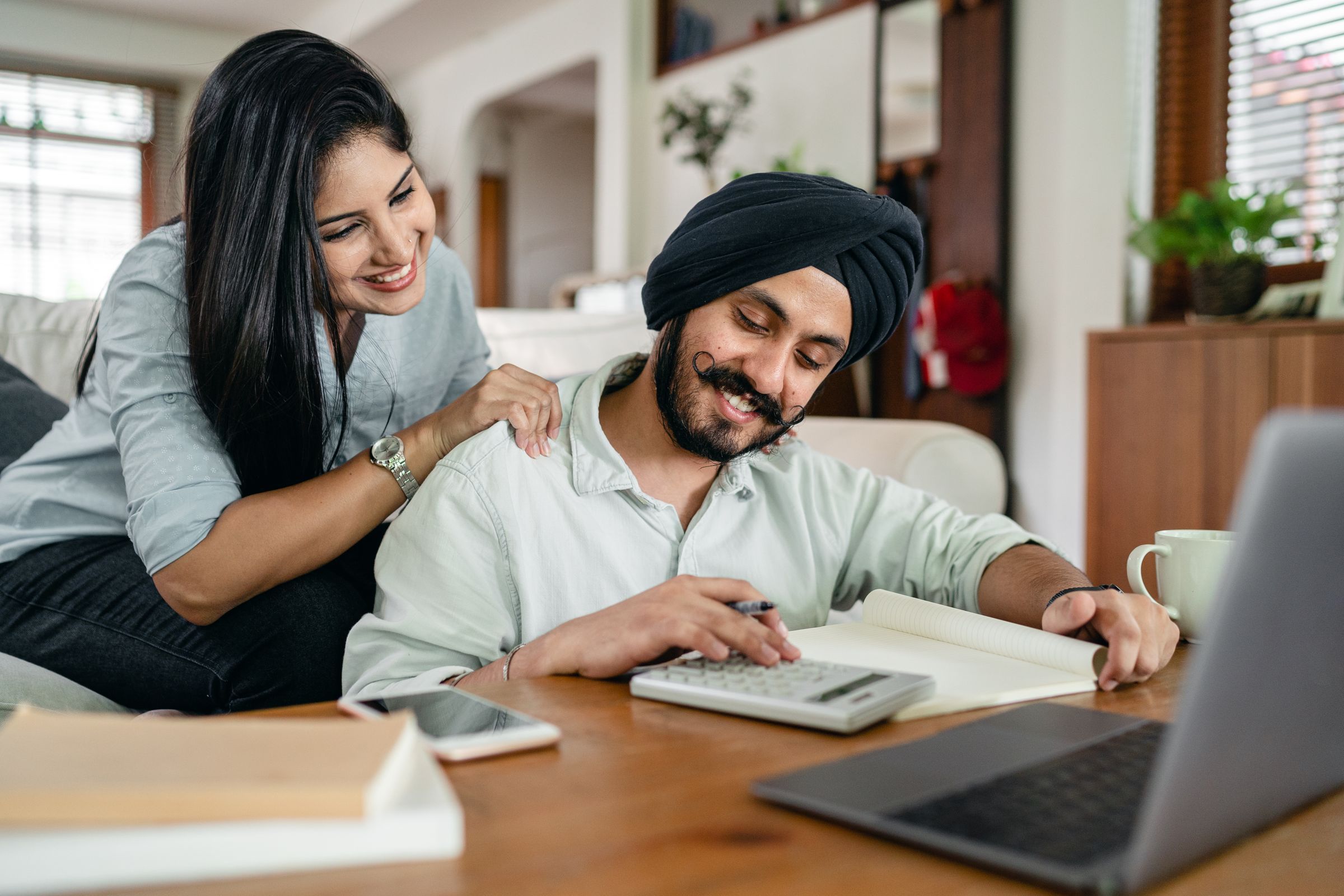 Two adults planning household accounts at a table, everyday commerce and accountancy